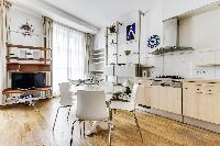 lovely dining area, multimedia cabinet and kitchen in a 2-bedroom Paris luxury apartment