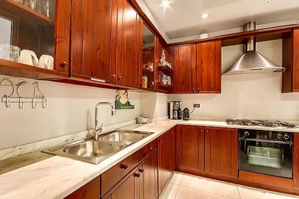 spacious fully-equipped kitchen with built-in wooden cupboards in a 3-bedroom Paris luxury apartment