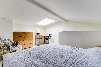 brand-new queen-size bed in the bedroom with sofa and study table beneath a skylight