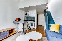 living area and dining area with comfortable blue sofa and breakfast bar