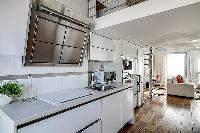 well-equipped white kitchen in a 1-bedroom loft Paris luxury apartment