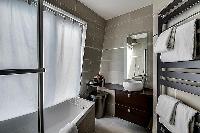 contemporary bathroom with toilet, sink, towel rack, and a bathtub with a detachable shower head in 