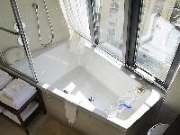 contemporary bathroom with toilet, sink, towel rack, and a bathtub with a detachable shower head in 