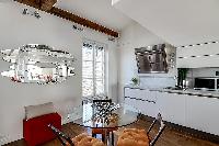 three-seater dining set and a sofa in a 1-bedroom loft Paris luxury apartment