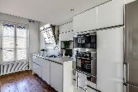 well-equipped white kitchen in a 1-bedroom loft Paris luxury apartment