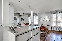 well-equipped white kitchen in a 1-bedroom loft Paris luxury apartment