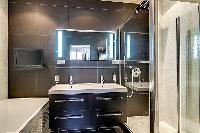 an en-suite bathroom in which a sink, toilet, and a shower area in a 2-bedroom paris luxury apartmen