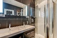 an en-suite bathroom in which a sink, toilet, and a shower area in a 2-bedroom paris luxury apartmen