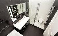 an en-suite bathroom in which a sink, toilet, and a shower area in a 2-bedroom paris luxury apartmen