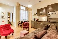 contemporary living area with golden brown velevet sofa and colorful velvet chairs, mini dining area