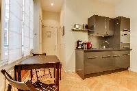 mini dining area and sleek compact gray kitchen in Paris luxury apartment