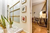 entrance door with framed artworks and potted plants in Paris luxury apartment