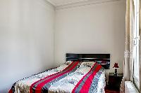 second bedroom with a double bed and bedside tables  in a 3-bedroom Paris luxury apartment