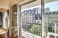 living area illuminated by the French windows that line the sides, giving the room a fresh and vibra