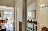 elegant bathroom with a full bathtub, a detachable shower head, built-in cabinets, a sink, and a van