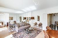 tastefully decorated living area with two armchairs, a center table, a media shelf with a television