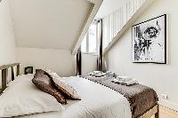 master bedroom with queen-size bed, fresh linens and towels in a 3-bedroom Paris luxury apartment