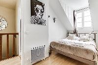 second bedroom with a double bed, fresh linens and towels in a 3-bedroom Paris luxury apartment