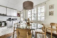 fully-equipped kitchen with four-seater dining set in a 3-bedroom Paris luxury apartment