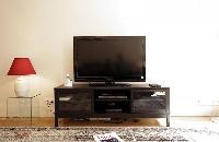 a media shelf with television in a 1-bedroom Paris luxury apartment