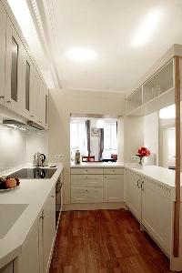 pristine white fully-equipped kitchen in a 1-bedroom Paris luxury apartment