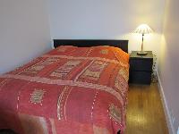relaxing double bed with a side table and lamp in a studio Paris luxury apartment