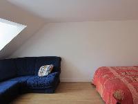 comfortable bed and blue sofa in a studio Paris luxury apartment