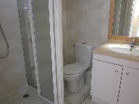 white bathroom with a sink, built-in cabinet, a toilet, and a shower in a studio Paris luxury apartm