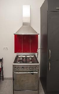 modern well-equipped kitchen in ed and gray hues in a 2-bedroom Paris luxury apartment