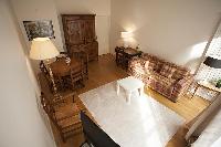 living area with a sofa, a center table, a desk, a chair, a TV and a lamp in a 2-bedroom Paris luxur