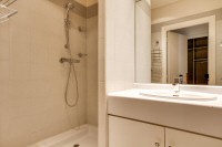 second bedroom fully-equipped with a shower, a sink, a toilet, and a mirror in a 2-bedroom Paris lux
