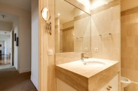 first bathroom elegantly furnished with a sink, a mirror, a toilet, and a full bathroom with a detac