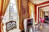 tastefully decorated 1-bedroom Paris luxury apartment in a traditional style, with gold, brown, and 