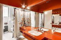 elegant bathroom with wooden sink counters, numerous mirrors, and pin lights, fully-equipped with a 