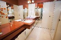 elegant bathroom with wooden sink counters, numerous mirrors, and pin lights, fully-equipped with a 