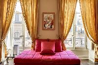 comfortable red sofa and elegant curtains in a 1-bedroom Paris luxury apartment