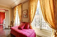 comfortable red sofa and elegant curtains in a 1-bedroom Paris luxury apartment