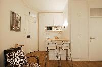 space efficient kitchen with breakfast bar and stools in a 1-bedroom Paris luxury apartment