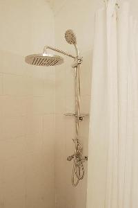 bathroom with a sink, a mirror, a toilet, and a shower area in a 1-bedroom Paris luxury apartment