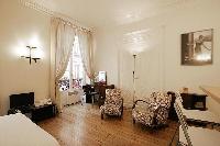 living area with a dressing table with mirror and a chair, a media shelf, double bed and a televisio