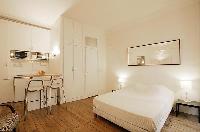 sleeping area with two bedside tables, two lamps, and a double bed in a 1-bedroom Paris luxury apart