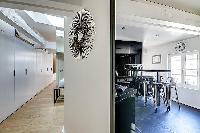 hallway filled with closets and spacious and monochromatic kitchen in Paris luxury apartment