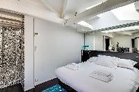 first bedroom with a king-size bed and en suite bathroom in Paris luxury apartment