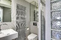 second bathroom fully-furnished with a toilet, a sink, and a shower area in Paris luxury apartment