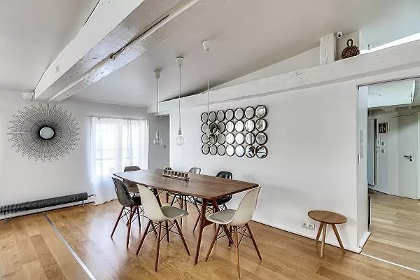 dining area with a long wooden table and six modern chairs in Paris luxury apartment