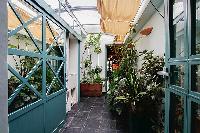 lovely patio with numerous plants illuminated by the skylight in a 3-bedroom Paris luxury apartment