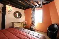 first bedroom with a queen size bed,  wooden floor, closet, nightstand in a 2-bedroom Paris luxury a
