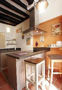 modern well-equipped kitchen with breakfast bar and stools in a 2-bedroom Paris luxury apartment