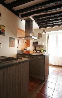 modern well-equipped kitchen with breakfast bar and stools in a 2-bedroom Paris luxury apartment