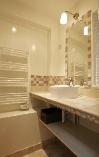 first bathroom with tiled floor, shower, sink, hairdryer, and separate toilet in a 2-bedroom Paris l